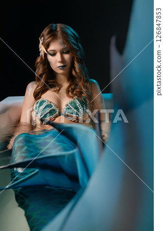 Woman posing as a mermaid in body art at a cosplay event in a studio 126847853