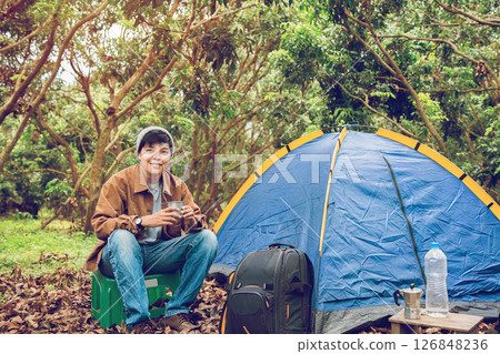 Asian lesbian sitting holding cup drinking espresso with Italian Moka coffee pot drinking in a forest on vacation, traveler outdoor the tent happy single picnic camping on the morning Asian lesbian sitting holding cup drinking espresso with Italian Moka coffee pot drinking in a forest on vacation, traveler outdoor the tent happy single picnic camping on the morning 126848236