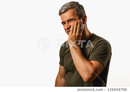 Man expressing discomfort while touching his face in a studio 126848706