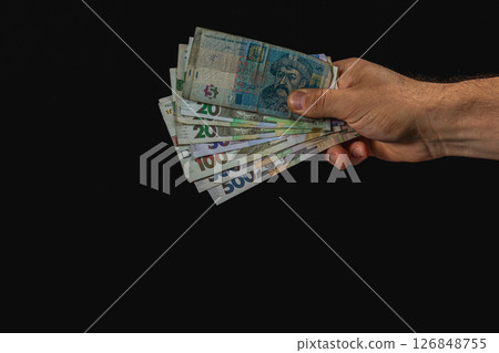 Hand holding banknotes against dark background 126848755