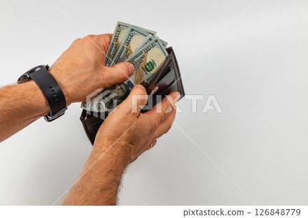 Hands exchanging cash from a wallet on a white surface 126848779
