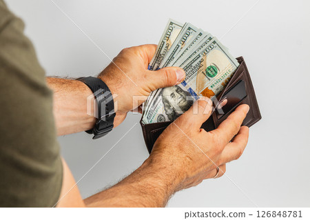 Person holds cash and wallet in hand with financial focus 126848781