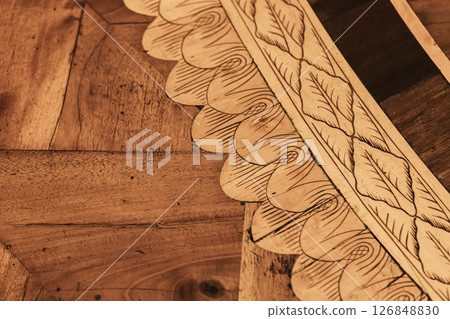 Detailed wooden parquet panels with intricate carvings of leaves and swirls 126848830