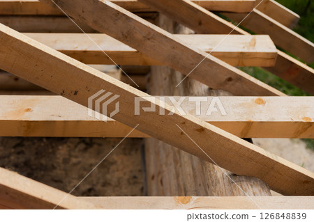 Detailed view of wooden beams forming the support structure for roof 126848839