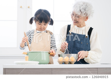 Girl and senior woman standing in the kitchen Cooking image 126848915