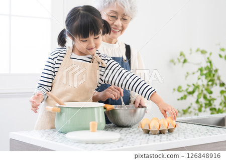 Girl and senior woman standing in the kitchen Cooking image 126848916