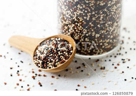 Mix of white, black and red quinoa seeds in wooden spoon. Mix of white, black and red quinoa seeds in wooden spoon. 126850879