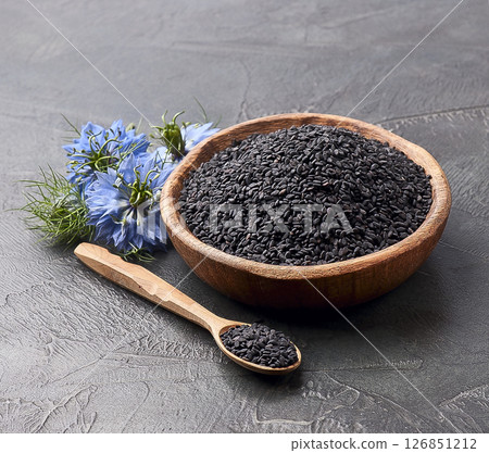 Black cumin seed and nigella flower in wooden plate on concrete backgrounds 126851212