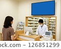 A female patient and a pharmacist waiting to receive medicine at a pharmacy 126851299
