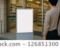 Back view of a man looking at a signage/information sign in front of a pharmacy 126851300