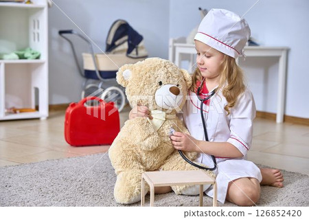 Little Girl Pretends to be Doctor with Teddy Bear Little Girl Pretends to be Doctor with Teddy Bear 126852420