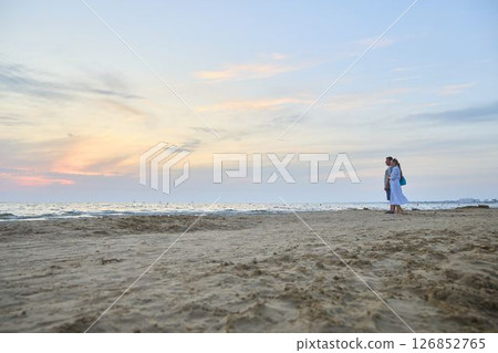 Family Enjoying Scenic Sunset on a Quiet Beach 126852765