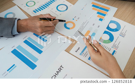 Analyzing Financial Data. Close-up of hands reviewing charts and graphs during a business meeting. 126852818