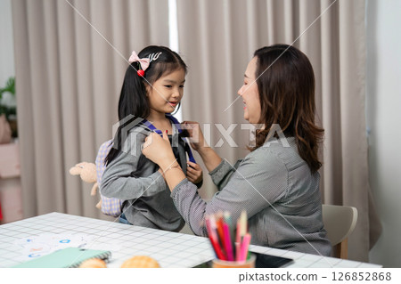Inclusive Health and Wellness. A mother playfully checks her daughter's heartbeat with a stethoscope. 126852868