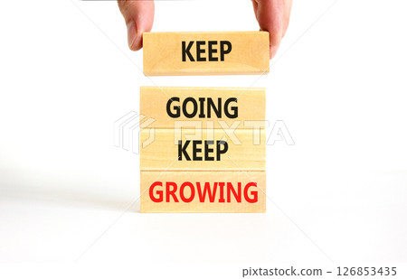 Keep going and growing symbol. Concept words phrase Keep going keep growing on beautiful wooden blocks. Beautiful white background. Businessman's hand. Business Keep going growing concept. Copy space. 126853435