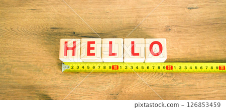 Hello symbol. Concept word Hello on beautiful wooden blocks. Beautiful wooden table wooden background. Beautiful yellow ruler. Business lifestyle hello concept. Copy space. Hello symbol. Concept word Hello on beautiful wooden blocks. Beautiful wooden table wooden background. Beautiful yellow ruler. Business lifestyle hello concept. Copy space. 126853459