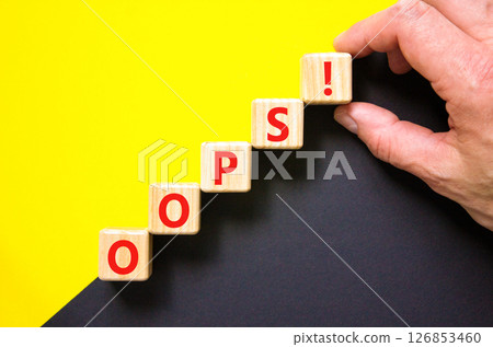 Oops symbol. Concept word Oops on beautiful wooden blocks. Beautiful yellow and black background. Businessman hand. Business lifestyle oops concept. Copy space. 126853460