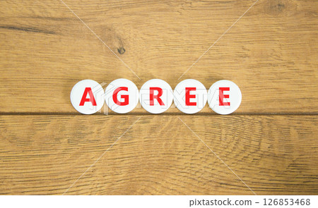 Agree symbol. Concept word Agree on beautiful white pills circles. Beautiful wooden table wooden background. Business agree concept. Copy space. Agree symbol. Concept word Agree on beautiful white pills circles. Beautiful wooden table wooden background. Business agree concept. Copy space. 126853468