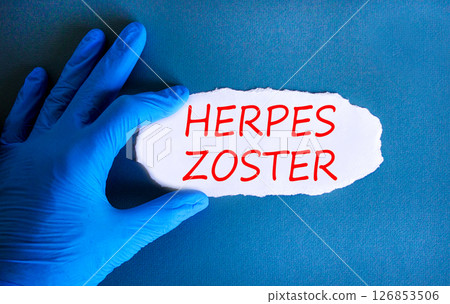 Herpes zoster symbol. Concept words Herpes zoster on beautiful white paper. Doctor's hand in blue medical glove. Beautiful blue background. Medical healthy lifestyle herpes zoster concept. 126853506