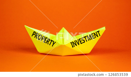 Property investment symbol. Concept words Property investment on beautiful yellow paper boat. Beautiful orange paper background. Business Property investment concept. Copy space. Property investment symbol. Concept words Property investment on beautiful yellow paper boat. Beautiful orange paper background. Business Property investment concept. Copy space. 126853539