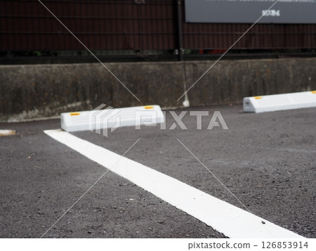 Shadows drawn on the road surface, image of a parking lot, copy space. Feel the scenery of a car space under the blue sky. Shadows drawn on the road surface, image of a parking lot, copy space. Feel the scenery of a car space under the blue sky. 126853914