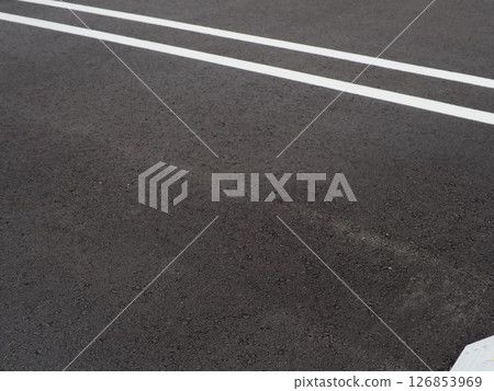 Shadows drawn on the road surface, image of a parking lot, copy space. Feel the scenery of a car space under the blue sky. 126853969
