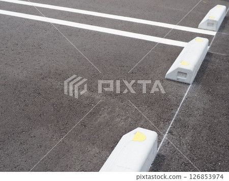Shadows drawn on the road surface, image of a parking lot, copy space. Feel the scenery of a car space under the blue sky. Shadows drawn on the road surface, image of a parking lot, copy space. Feel the scenery of a car space under the blue sky. 126853974