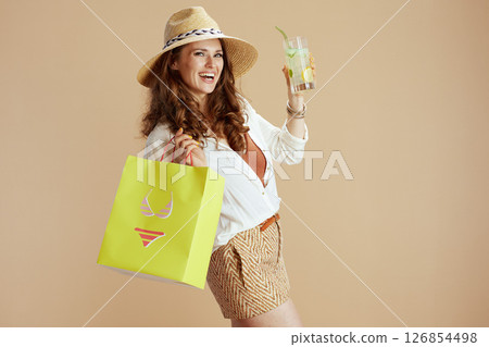 smiling housewife in blouse and shorts against beige 126854498
