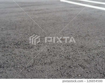 A scene from a parking lot. Copy space. Search for and feel the world hidden in the asphalt. Enjoy the time on a cloudy day. A scene from a parking lot. Copy space. Search for and feel the world hidden in the asphalt. Enjoy the time on a cloudy day. 126854580