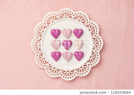Overhead view of heart chocolates placed on a plate with pink background and copy space 126854684