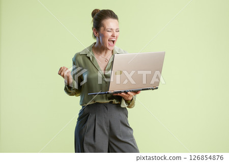 Celebrating success with laptop in studio Celebrating success with laptop in studio 126854876
