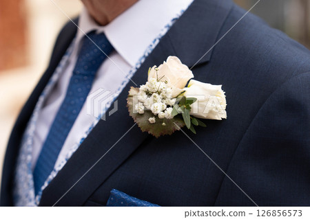 Groom at a wedding with a boutonniere of white gypsophila and rose Groom at a wedding with a boutonniere of white gypsophila and rose 126856573