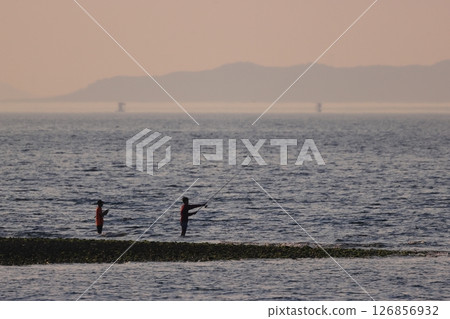 Brothers fishing on the beach in the evening 126856932