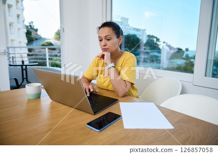 Confident Businesswoman Working Remotely from Home Office with Laptop Confident Businesswoman Working Remotely from Home Office with Laptop 126857058