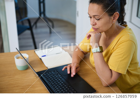 Focused Freelancer Working at Home on Laptop with Coffee 126857059