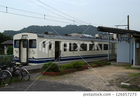 A one-car train stopped at a rural terminal 126857273