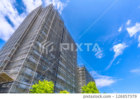 Yokohama cityscape in Japan. Apartment building repairs and inspections, scaffolding and protective nets. Satellite antennas outside the nets... 126857379
