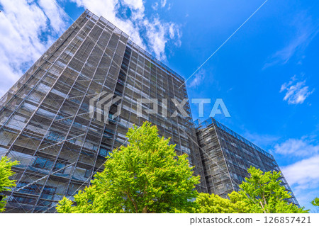 Yokohama cityscape in Japan. Apartment building repairs and inspections, scaffolding and protective nets. Satellite antennas outside the nets... 126857421