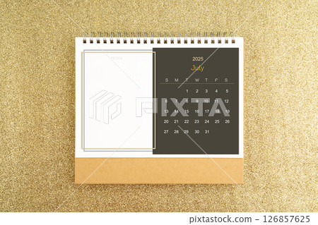 Desk calendar for July 2025 on gold glitter background. 126857625