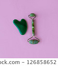 Jade massagers on a pink background. Square background. 126858652