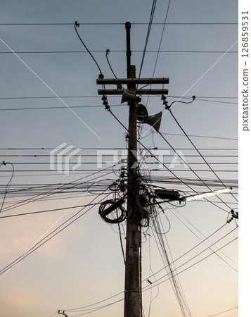 Rural Loudspeaker on Utility Pole with Tangled Cables at Sunset. 126859531