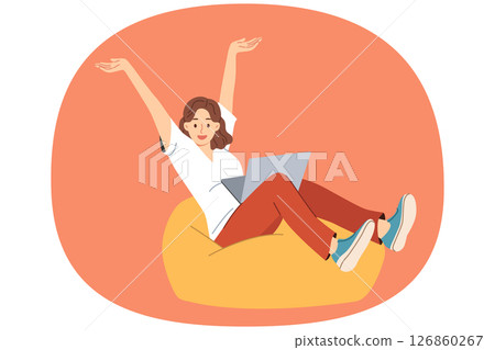 Woman freelancer joyfully raises hands after completing work on project, sitting with laptop on lap 126860267