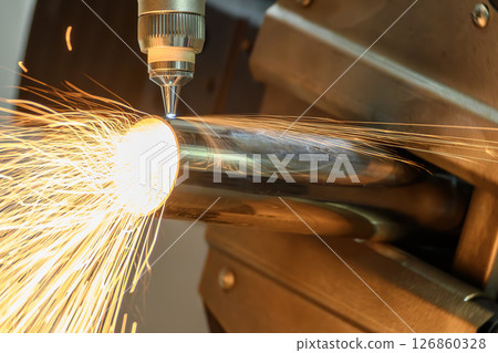 Close up scene the fiber laser cutting machine cut the stainless steel tube with sparkling light. 126860328