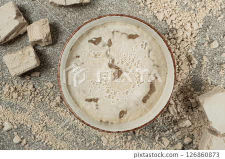 Activation of wet fresh yeast in warm water with sugar. 126860873