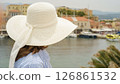 Tourist wearing white sun hat looking at chania venetian harbour in crete, greece 126861532