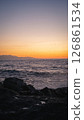 Waves crashing on rocks at sunset with birds flying over the ocean 126861534
