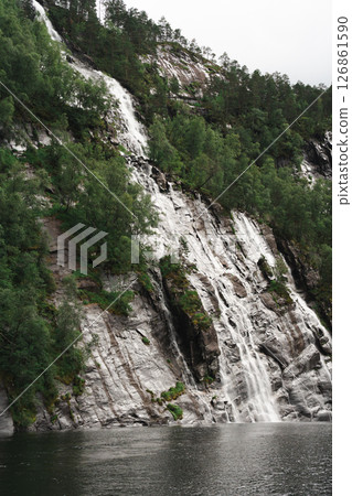 Waterfall flowing over rocky cliff into fjord near Bergen, Norway Waterfall flowing over rocky cliff into fjord near Bergen, Norway 126861590