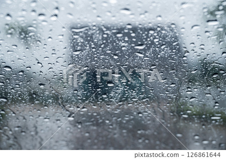 Dew drop on the car glass window during raining. Dew is the moisture that forms as a result of condensation. Dew drop on the car glass window during raining. Dew is the moisture that forms as a result of condensation. 126861644