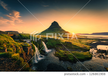 Sunrise over Kirkjufell mountain with waterfall flowing on moss field during summer at Iceland 126861908