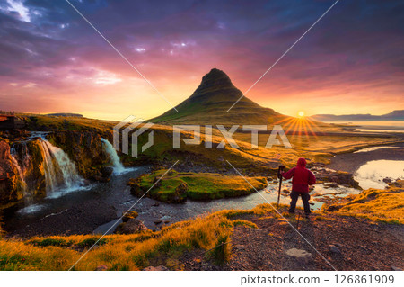 Colorful majestic sunrise over Kirkjufell mountain with photographer standing in autumn at Iceland 126861909